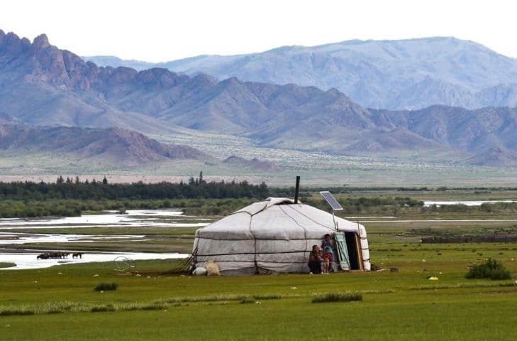 Step, a na nim jurta. Nad wejściem przymocowane baterie słoneczne, a przed wejściem siedzi mongolska rodzina. fot. pixabay